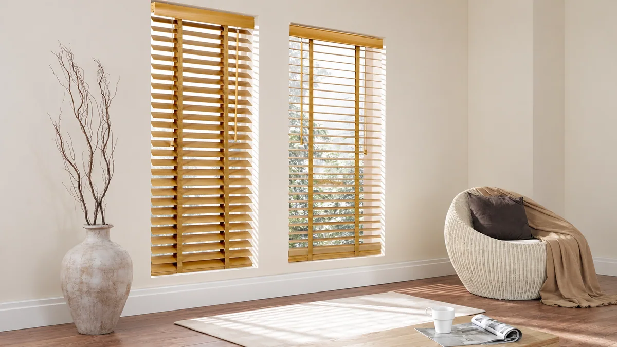 Natural wooden blinds casting warm linear light in a calm interior